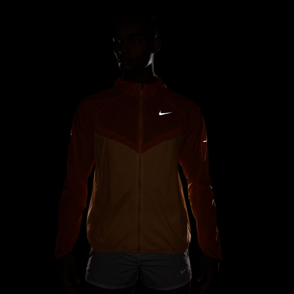 The reflective Swoosh logo on the front of the Nike Men's Stride Repel UV Running Jacket in the Bright Ceramic/Reflective Silver colourway. (8778203693218)