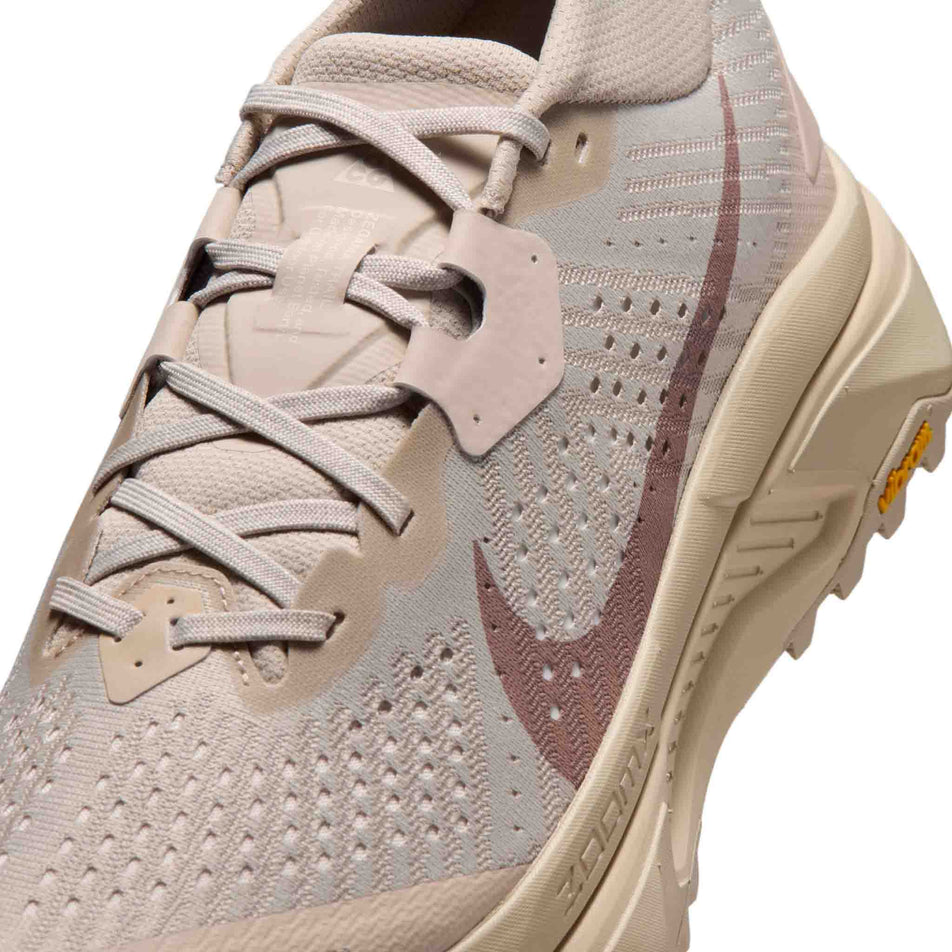 Close-up view of the upper of the left shoe from a pair of Nike Men's ACG Zegama Trail Running Shoes in the Cream II/Diffused Taupe-Light Orewood Brown colourway.