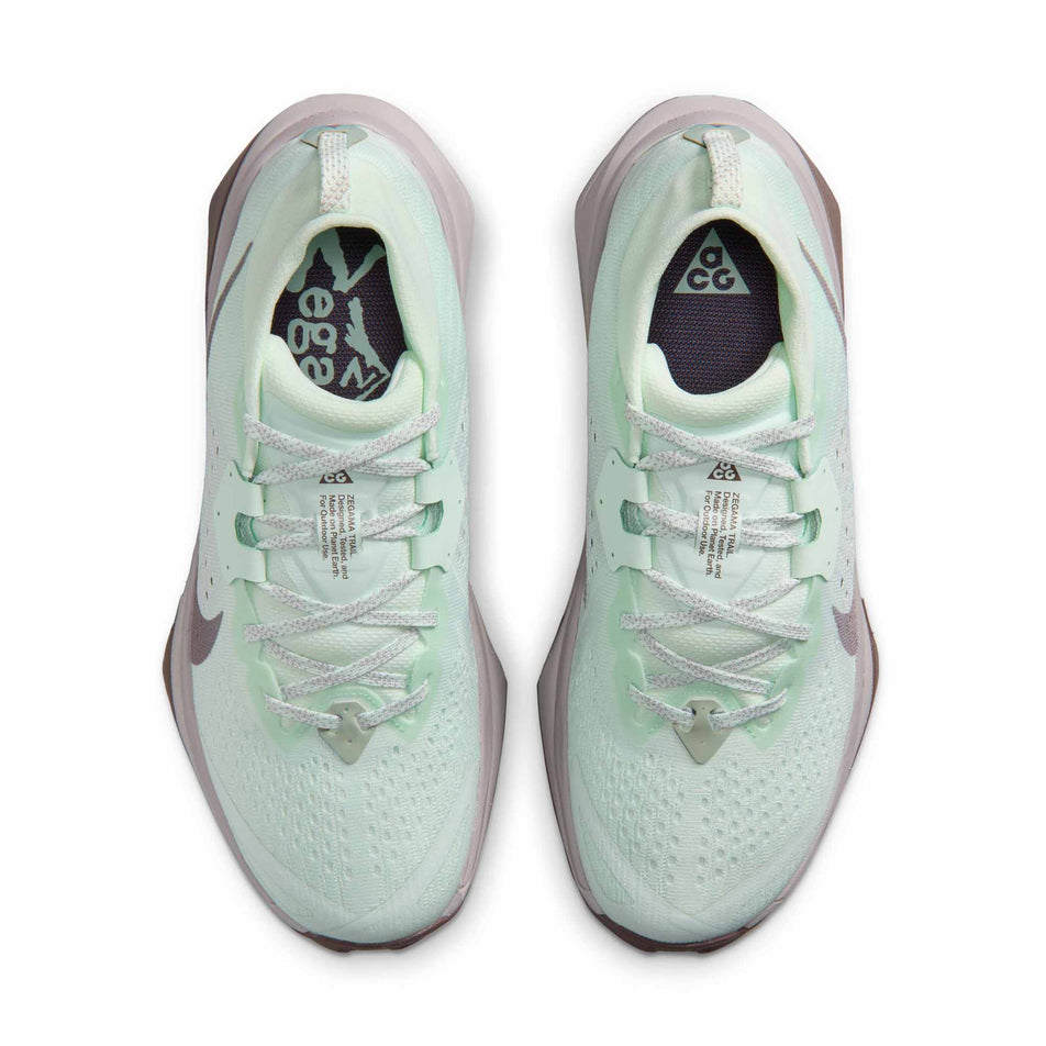 The uppers of a pair of Nike Women's ACG Zegama Trail Running Shoes in the Barely Green/Silver Lilac-Tattoo colourway.