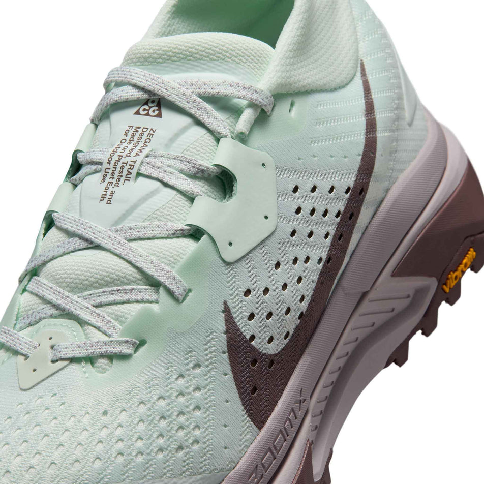 Close-up view of the upper of the left shoe from a pair of Nike Women's ACG Zegama Trail Running Shoes in the Barely Green/Silver Lilac-Tattoo colourway.