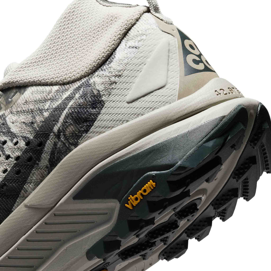 Close-up view of the rearfoot section of the left shoe from a pair of Nike Women's ACG Zegama Trail Running Shoes in the Spruce Fog/Black Spruce-Sea Glass-Black colourway.