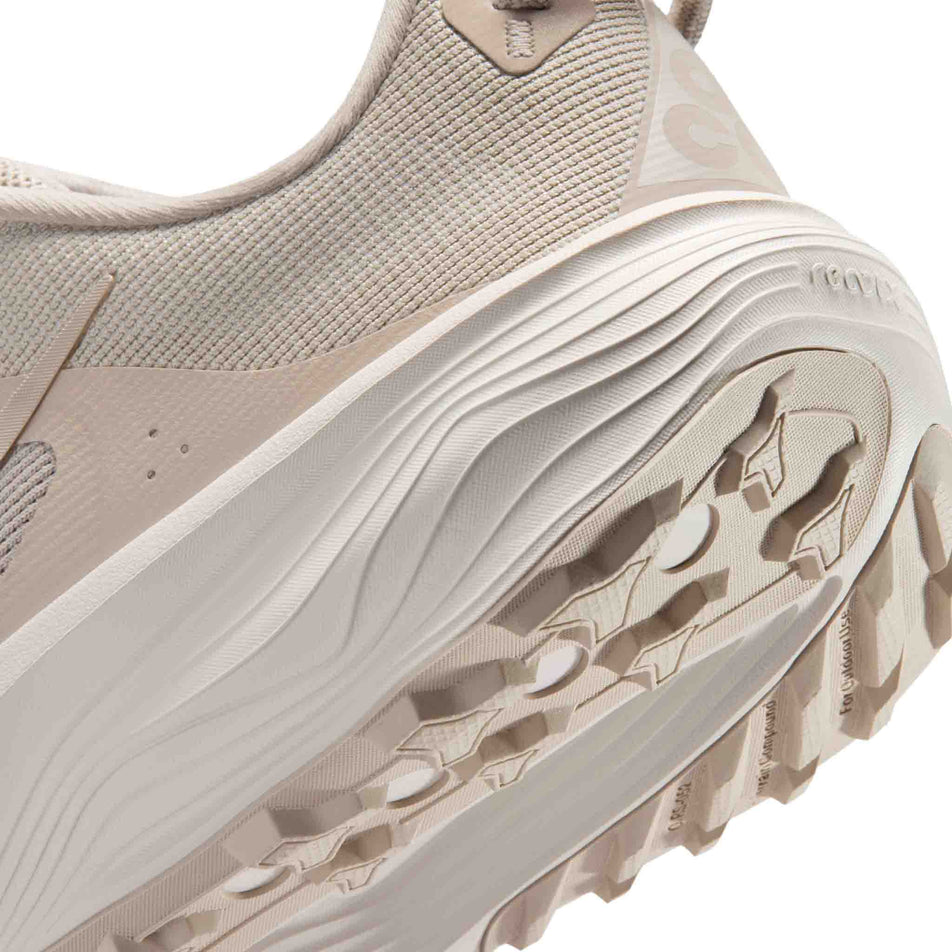 Close-up view of the rearfoot section of the left shoe from a pair of Nike Men's ACG Pegasus Trail Running Shoes in the Cream II/Cream II-Light Orewood Brown colourway.