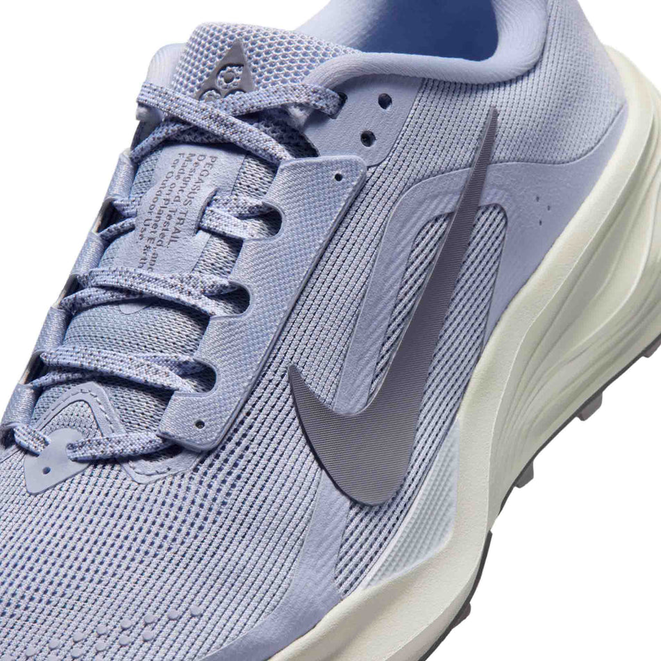 Close-up view of the upper of the left shoe from a pair of Nike Women's ACG Pegasus Trail Running Shoes in the Ghost/Cement Grey-Mineral Slate colourway.