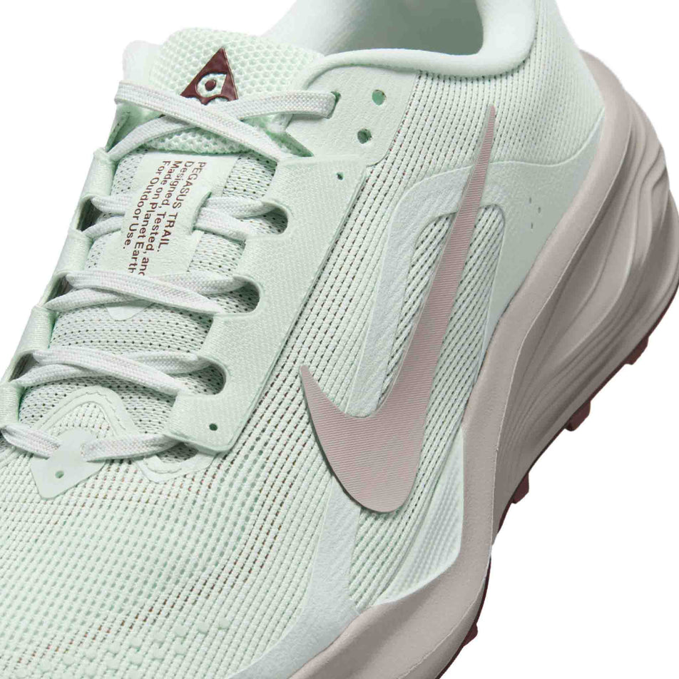 Close-up view of the upper of the left shoe from a pair of Nike Women's ACG Pegasus Trail Running Shoes in the Barely Green/Silver Lilac-Light Bone colourway.