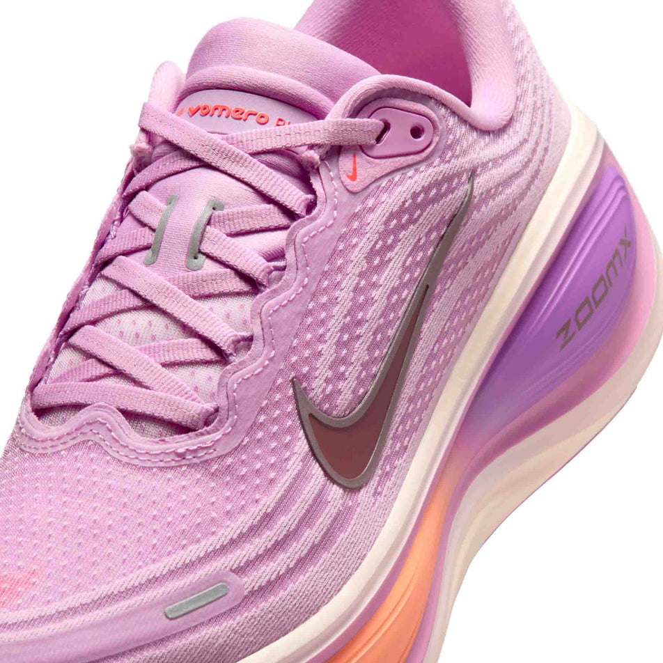 Close-up view of the upper of the left shoe from a pair of Nike Women's Vomero Plus Road Running Shoes in the Light Magenta/Black-Pink Foam-Bright Violet colourway.