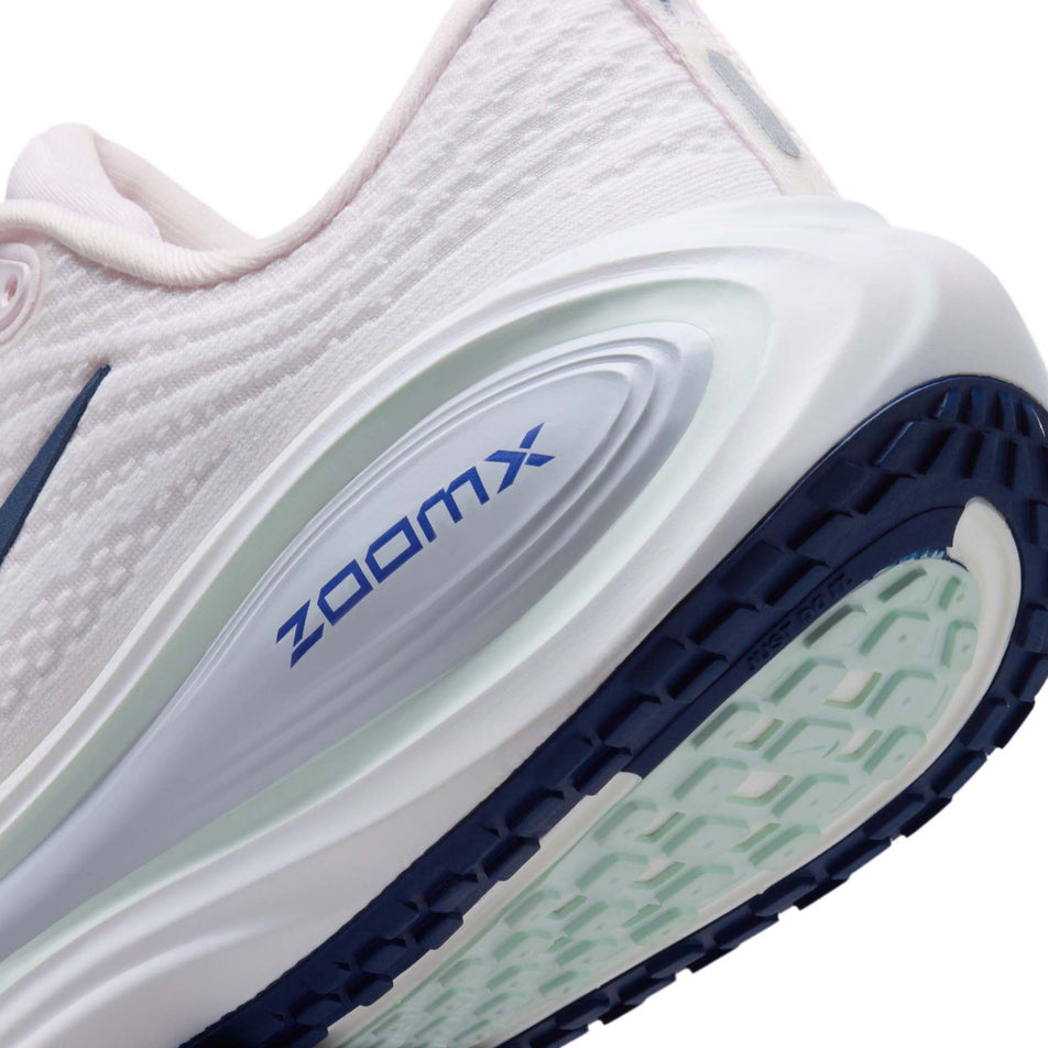 Close-up view of the rearfoot section of the left shoe from a pair of Nike Women's Vomero Plus Road Running Shoes in the Pearl Pink/Midnight Navy-White colourway.