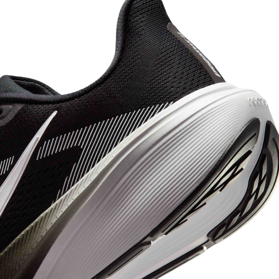 Close-up view of the rearfoot section of the left shoe from a pair of Nike Men's Pegasus 42 Road Running Shoes in the Black/White-Photon Dust colourway.