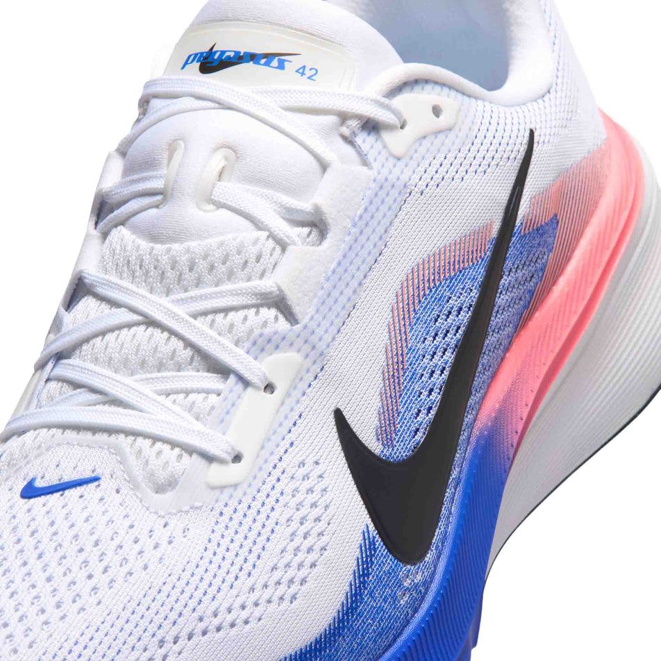 Close-up view of the upper of the left shoe from a pair of Nike Men's Pegasus 42 Road Running Shoes in the White/Black-Racer Blue-Atomic Pink colourway.