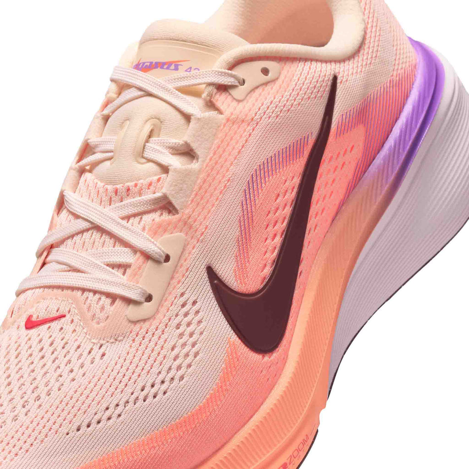 Close-up view of the upper of the left shoe from a pair of Nike Women's Pegasus 42 Road Running Shoes in the Chalk/Tattoo-Orange Pulse-Bright Violet colourway.