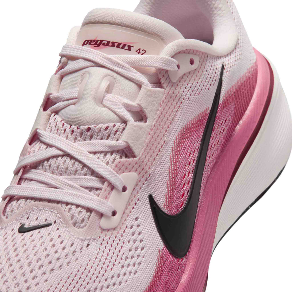 Close-up view of the upper of the left shoe from a pair of Nike Women's Pegasus 42 Road Running Shoes in the Pearl Pink/Black-Peony-Team Crimson colourway.