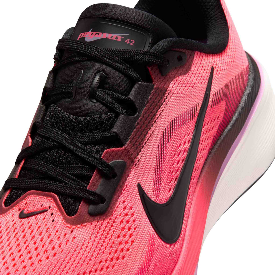 Close-up view of the upper of the left shoe from a pair of Nike Women's Pegasus 42 Road Running Shoes in the Lava Glow/Black-Flash Crimson-Light Magenta colourway.