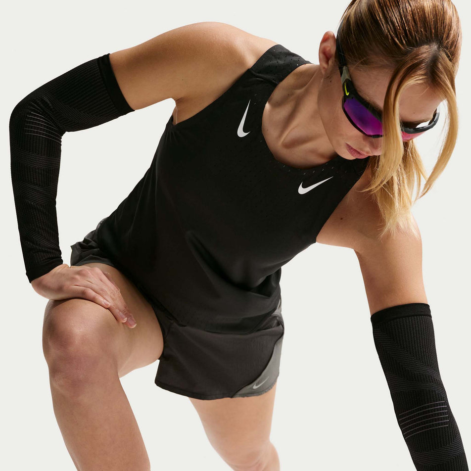Angled view of a model wearing the Nike Women's AeroSwift Dri-FIT ADV Running Singlet in the Black/White colourway.