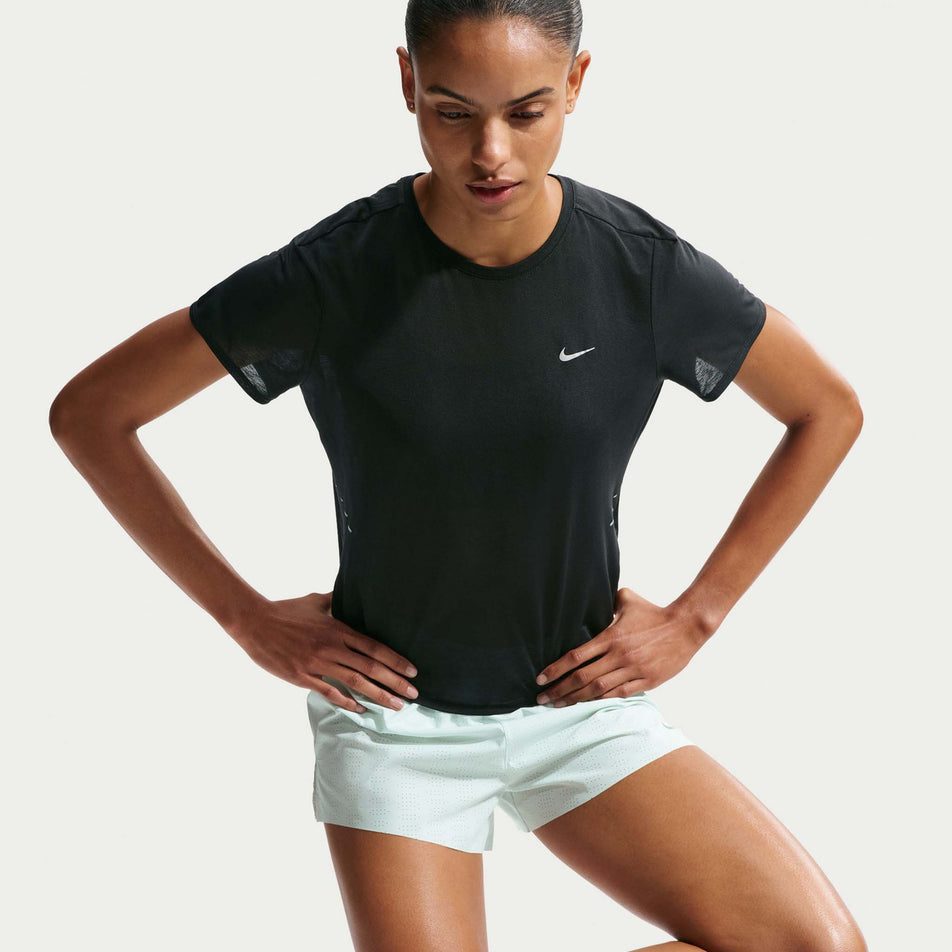 Front view of a model wearing the Nike Women's Swift Breathe Dri-FIT Short-Sleeve Running Top in the Black/Photon Dust/White/Reflective Silver colourway.
