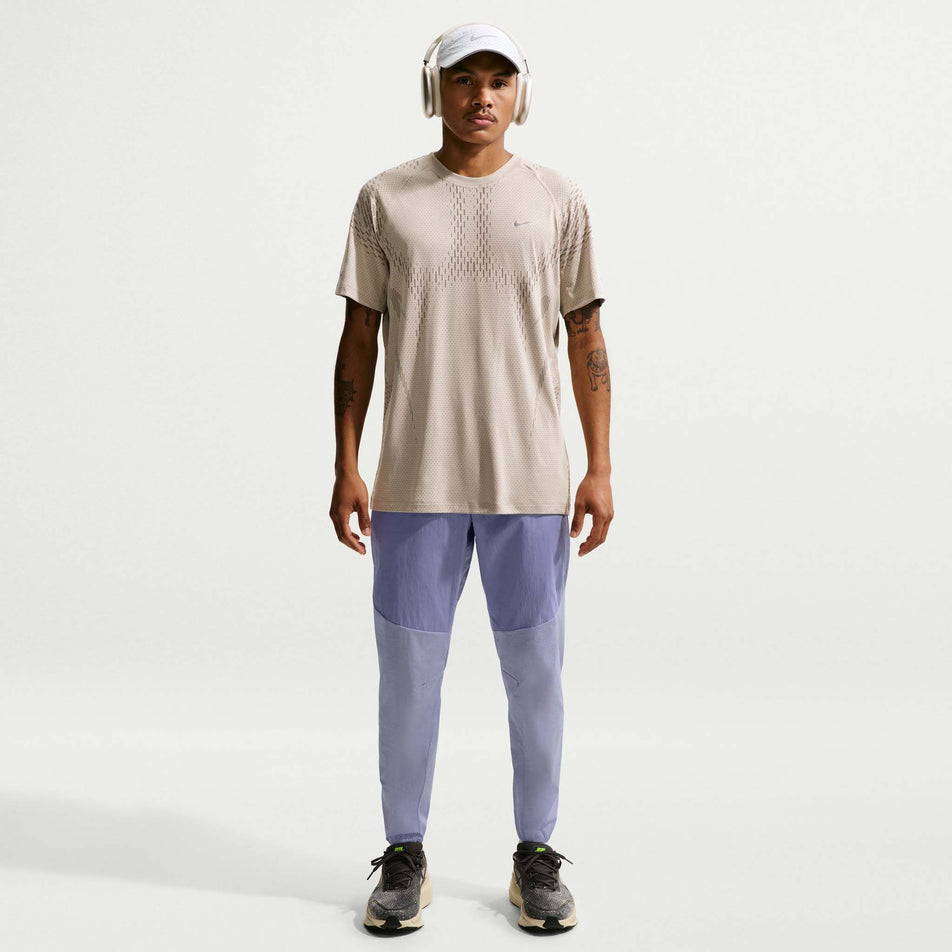 Front view of a model wearing the Nike Men's Stride Repel Woven Running Pants in the Iron Purple/Indigo Haze/Reflective Silver colourway.
