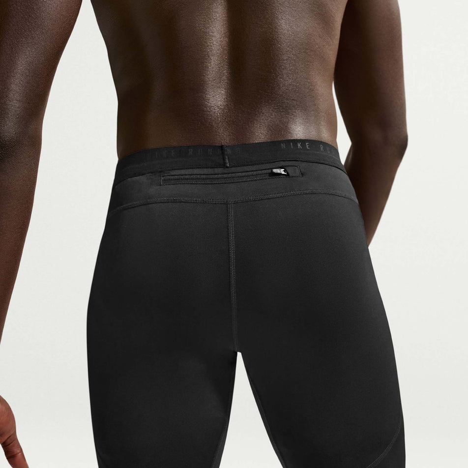 Back view of a model wearing the Nike Men's Stride Dri-FIT 1/2-Length Running Tights in the Black/Reflective Silver colourway.