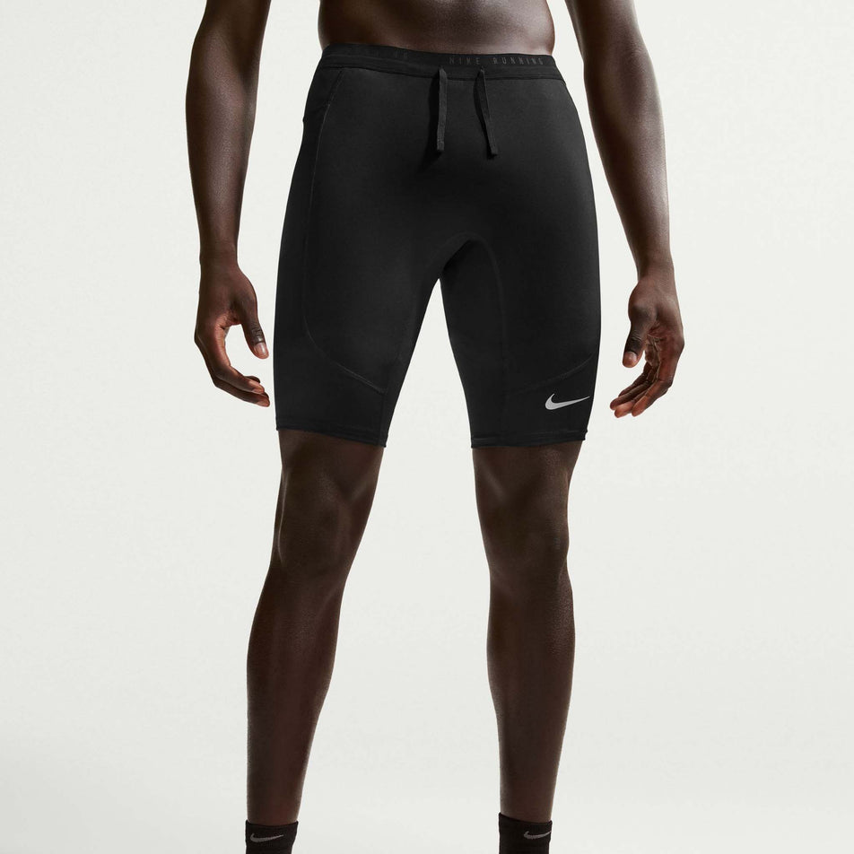 Front view of a model wearing the Nike Men's Stride Dri-FIT 1/2-Length Running Tights in the Black/Reflective Silver colourway.