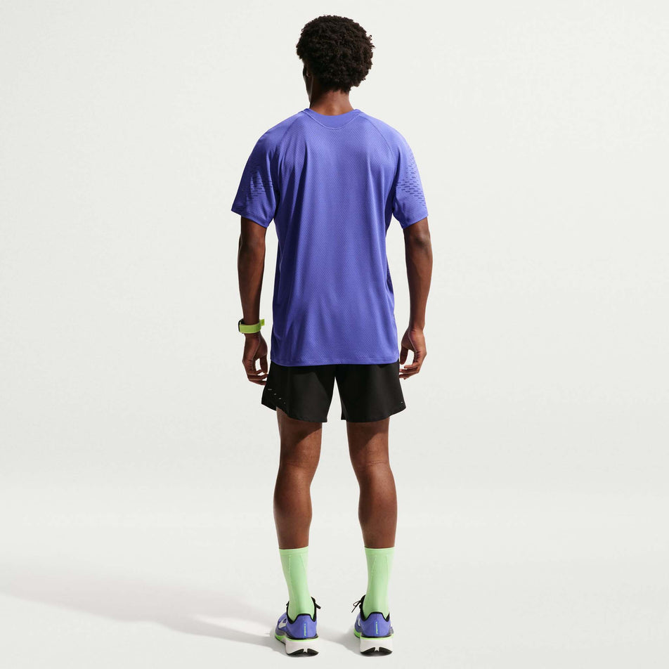 Back view of a model wearing the Nike Men's Stride Plus Dri-FIT ADV Short-Sleeve Running Top in the Lapis/Deep Royal Blue/Reflective Silver colourway.