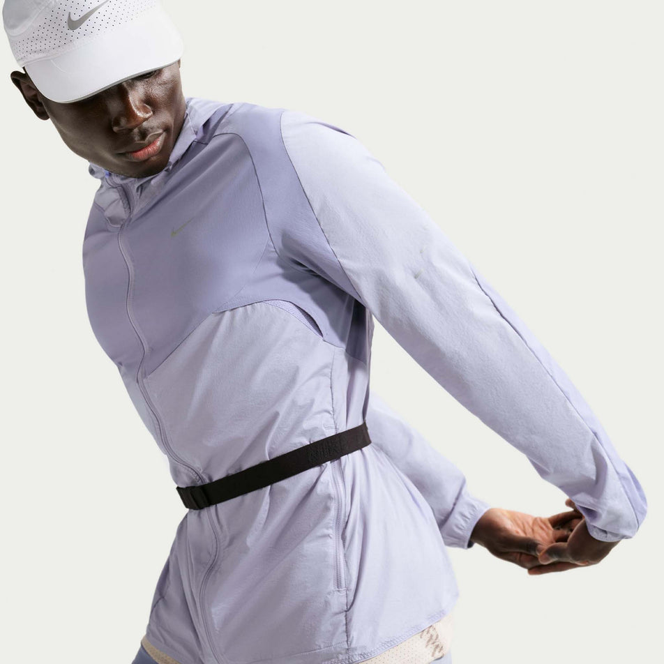Angled view of a model wearing the Nike Men's Stride Repel Running Jacket in the Iron Purple/Indigo Haze/Reflective Silver colourway.