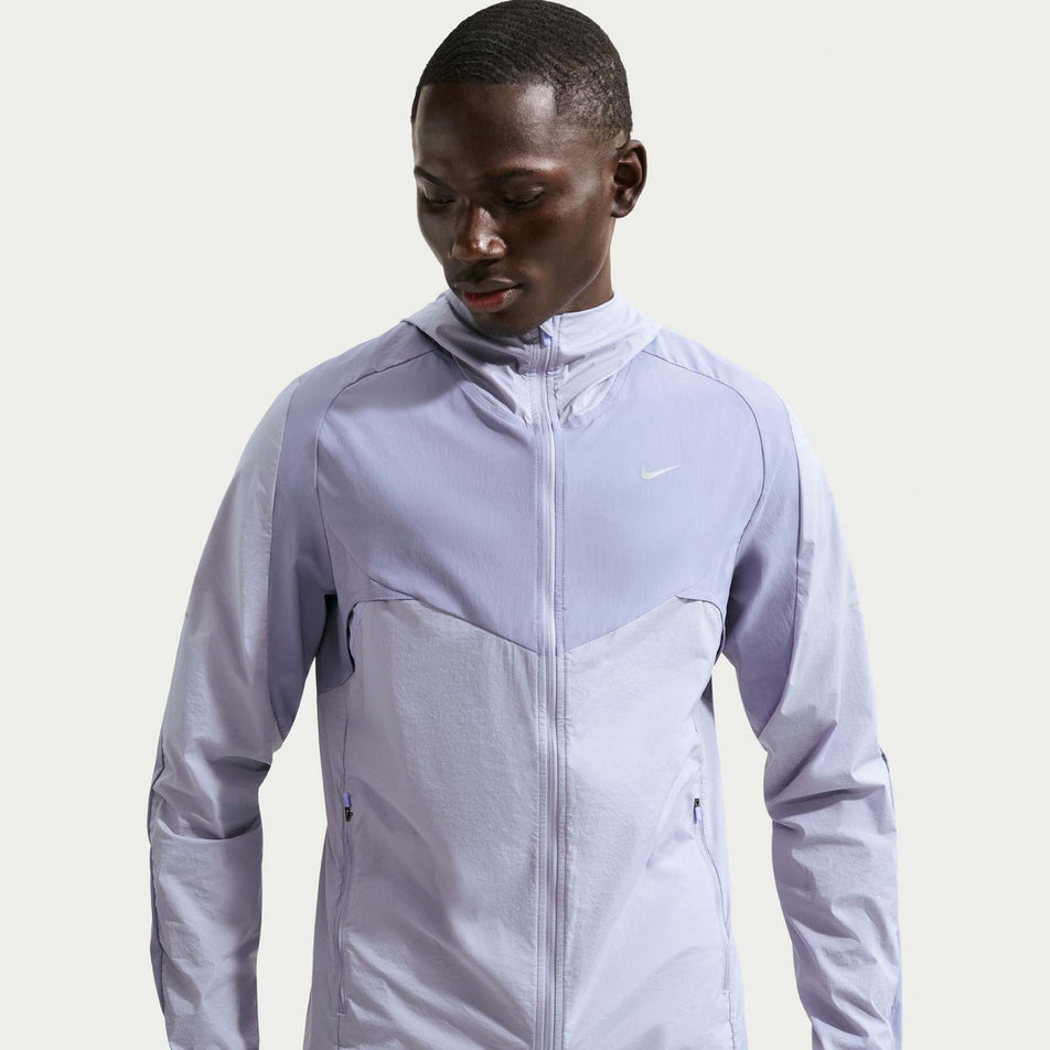Front view of a model wearing the Nike Men's Stride Repel Running Jacket in the Iron Purple/Indigo Haze/Reflective Silver colourway.