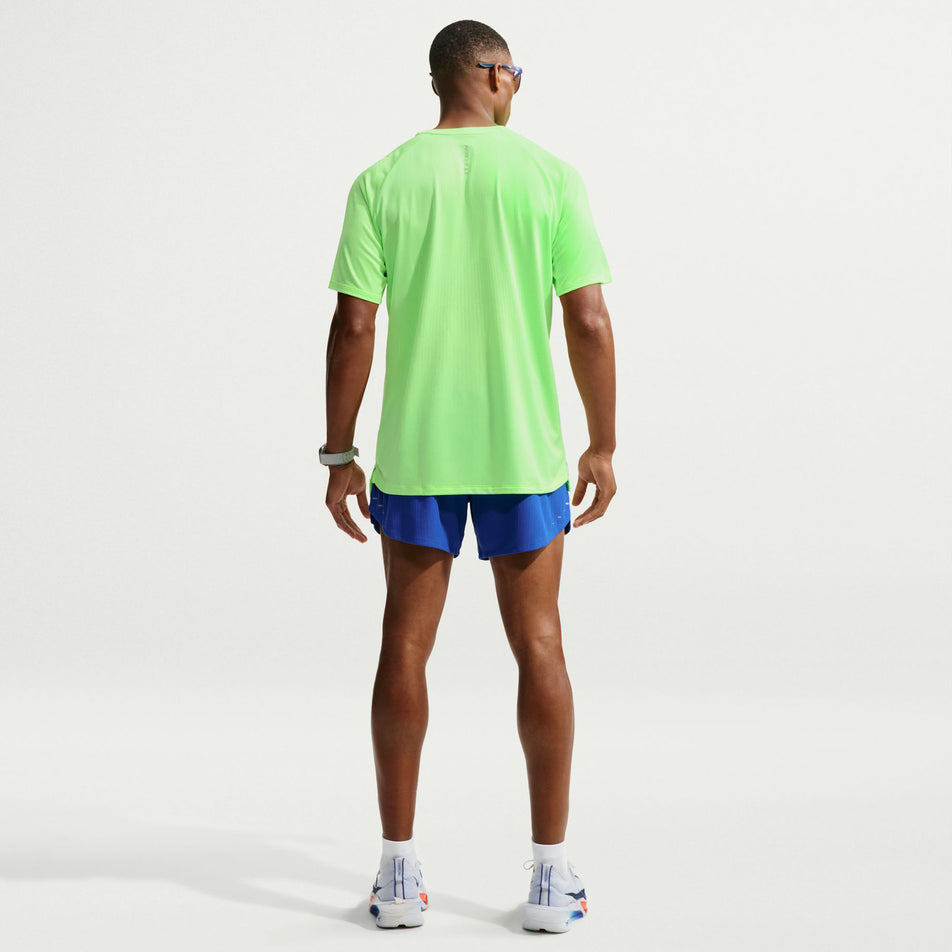 Back view of a model wearing the Nike Men's Stride Aero-FIT Short-Sleeve Running Top in the Volt/Light Silver/Reflective Silvern colourway.