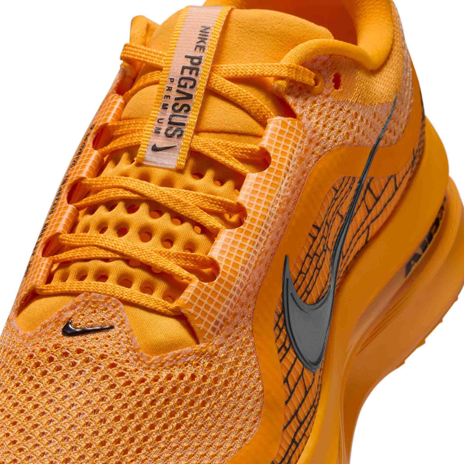 Close up of the upper of the left shoe from a pair of Nike Men's Pegasus Premium Road Running Shoes in the University Gold/Black-Laser Orange colourway. (8683467800738)