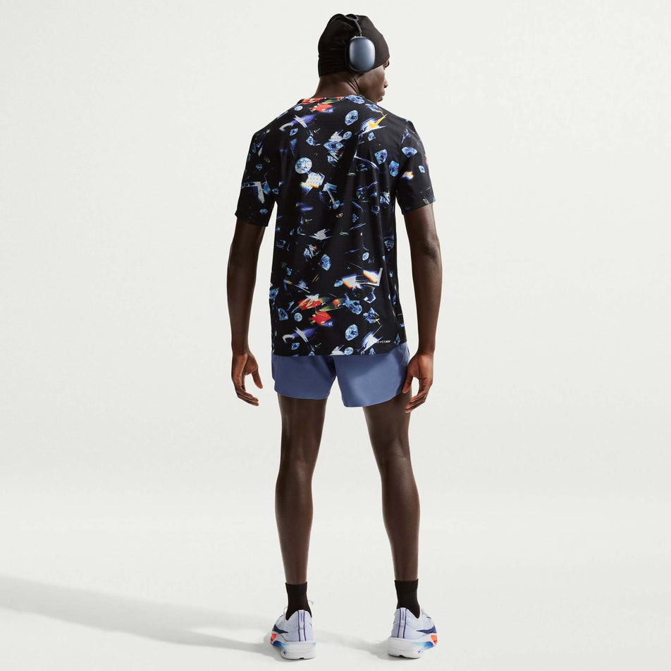 Back view of a model wearing the Nike Men's AeroSwift Dri-FIT ADV Short-Sleeve Running Top in the Black/Laser Orange colourway.