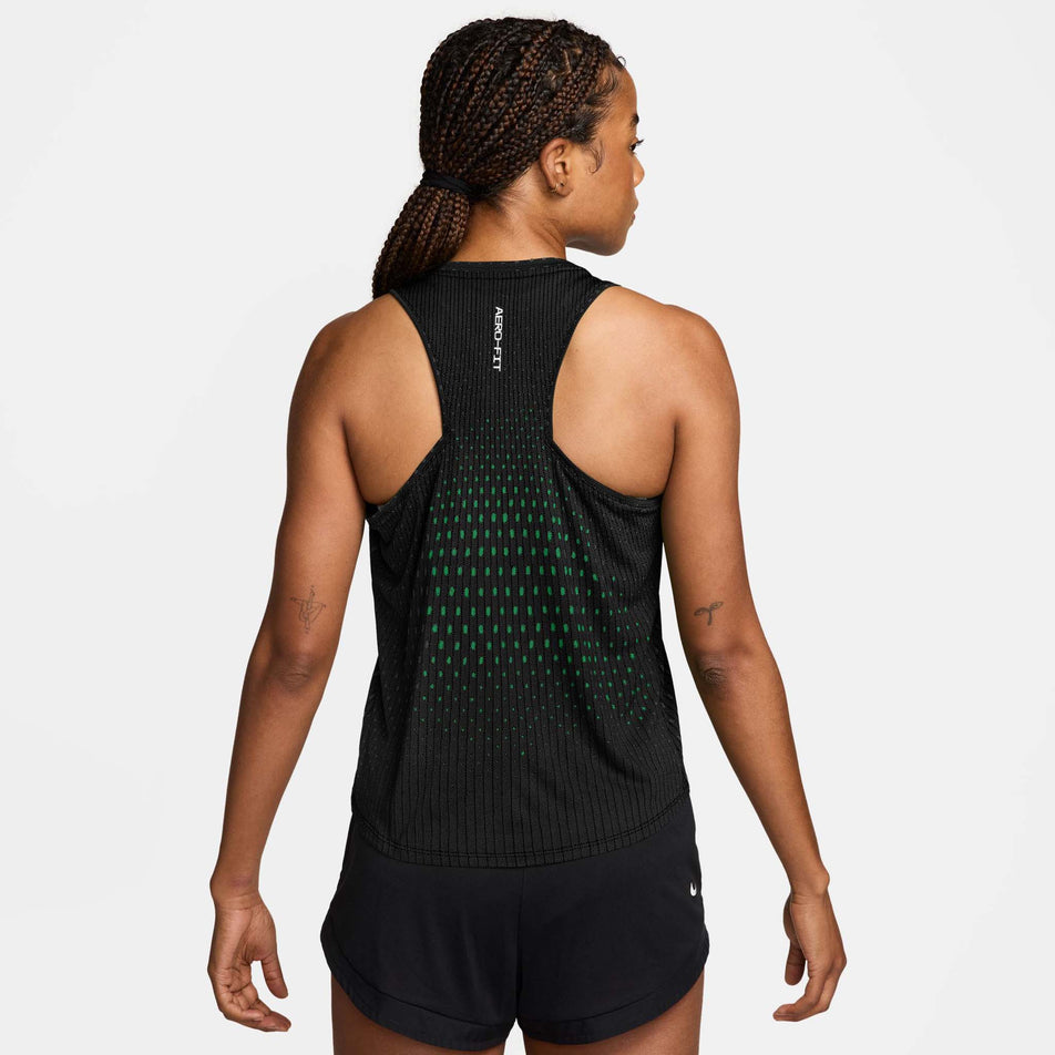 Back view of a model wearing the Nike Women's Swift Aero-FIT Running Tank Top in the Black/Light Green Spark/Reflective Silver colourway.