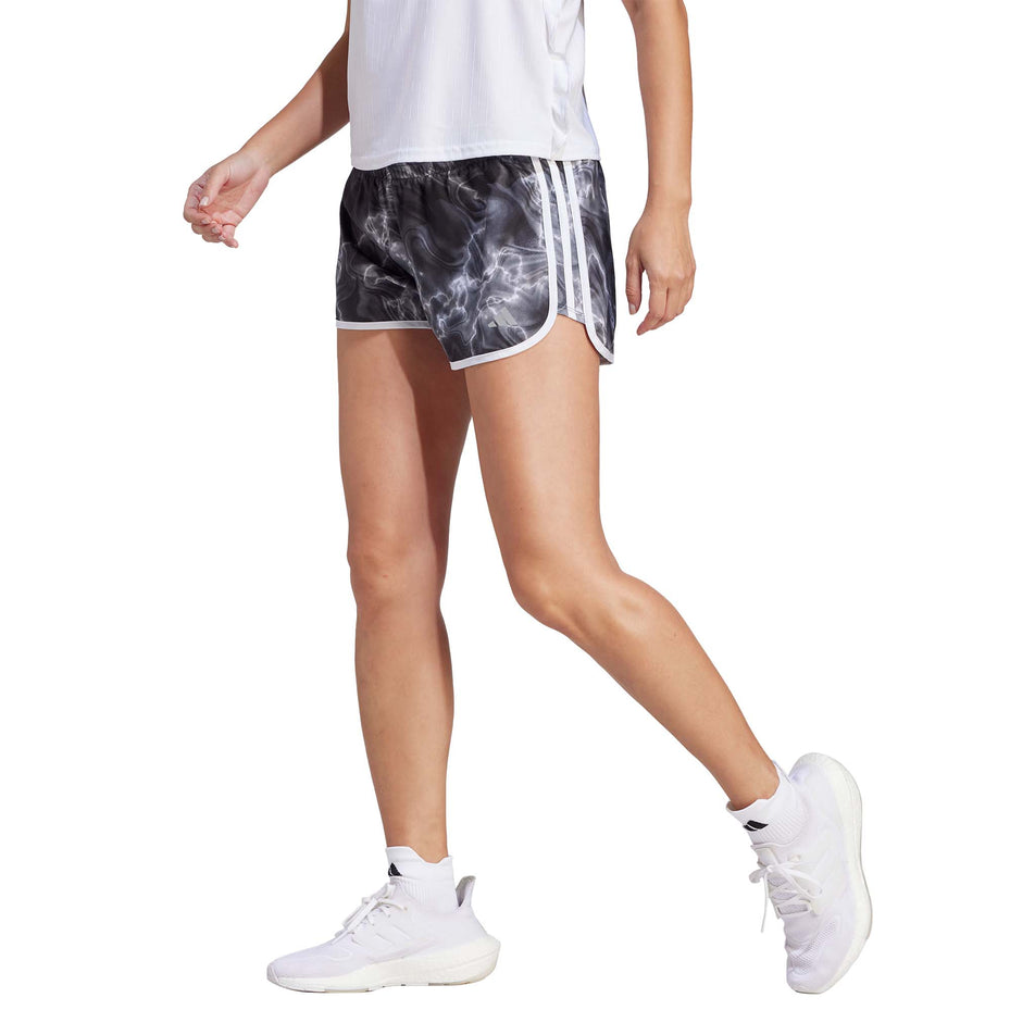 Angled front side view of a model wearing a pair of adidas Women's Marathon 20 Allover Print Shorts in the White/Black/Grey Six colourway (8005354291362)