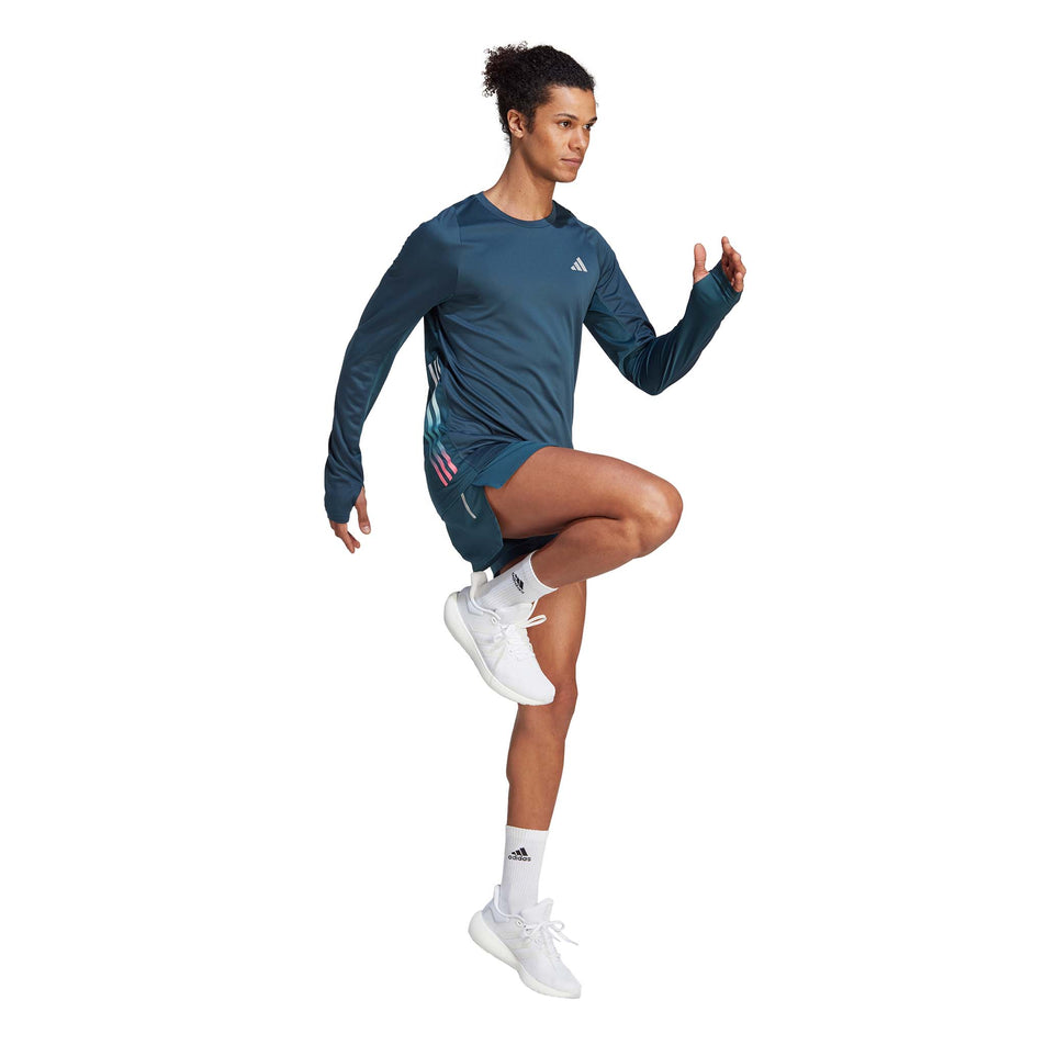 Angled front view of a model wearing an adidas Men's Run Icons 3-Stripes Long Sleeve Top in the Arctic Night colourway (8005293670562)