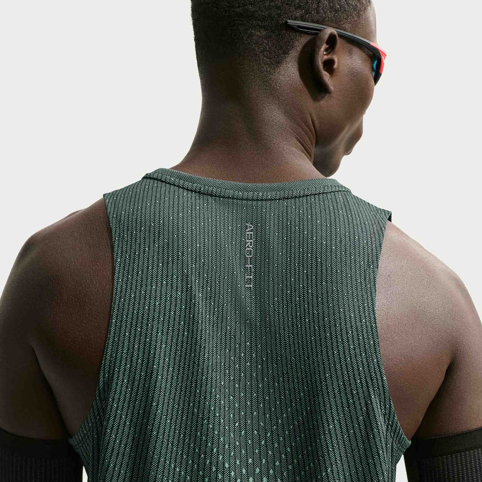 Back view of a model wearing the Nike Men's Stride Aero-FIT Running Tank Top in the Black/Light Green Spark/Reflective Silver colourway.