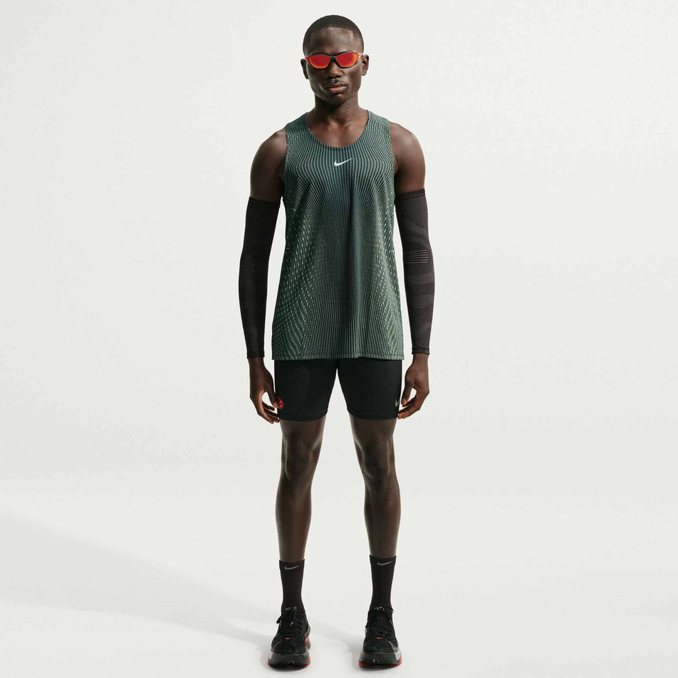 Front view of a model wearing the Nike Men's Stride Aero-FIT Running Tank Top in the Black/Light Green Spark/Reflective Silver colourway.