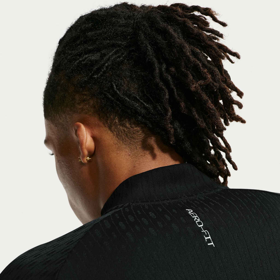 Front view of a model wearing the Nike Men's Stride Aero-FIT 1/2-Zip Mid Layer in the Black/Reflective Silver colourway. 