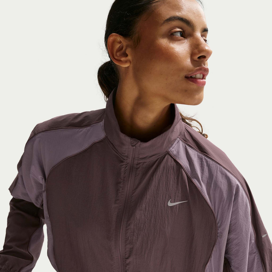 Front view of a model wearing the Nike Women's Swift Repel UV Protection Running Jacket in the Tattoo/Light Violet Ore/Reflective Silver colourway.