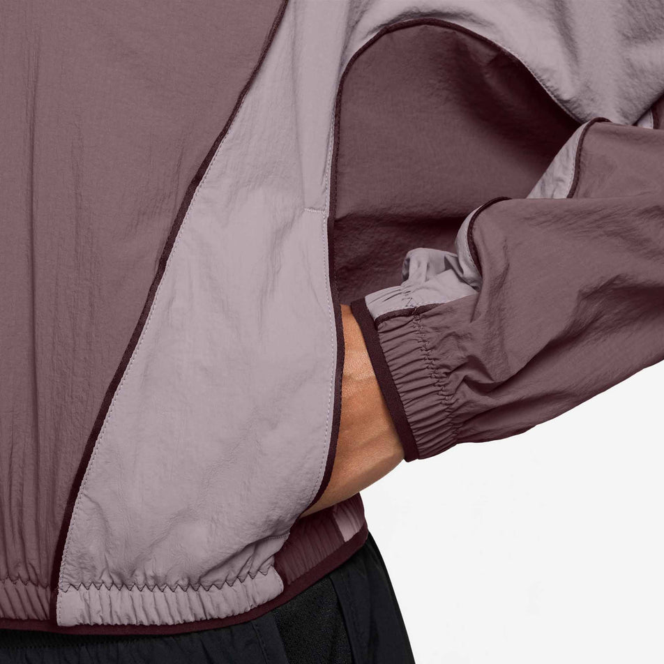 The pocket on the side of the Nike Women's Swift Repel UV Protection Running Jacket in the Tattoo/Light Violet Ore/Reflective Silver colourway.