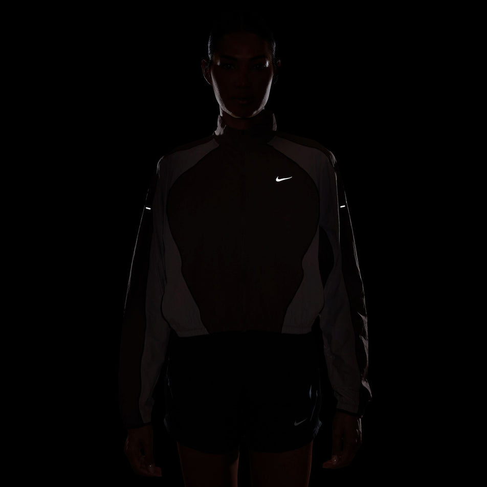 The reflective details on the Nike Women's Swift Repel UV Protection Running Jacket in the Tattoo/Light Violet Ore/Reflective Silver colourway.