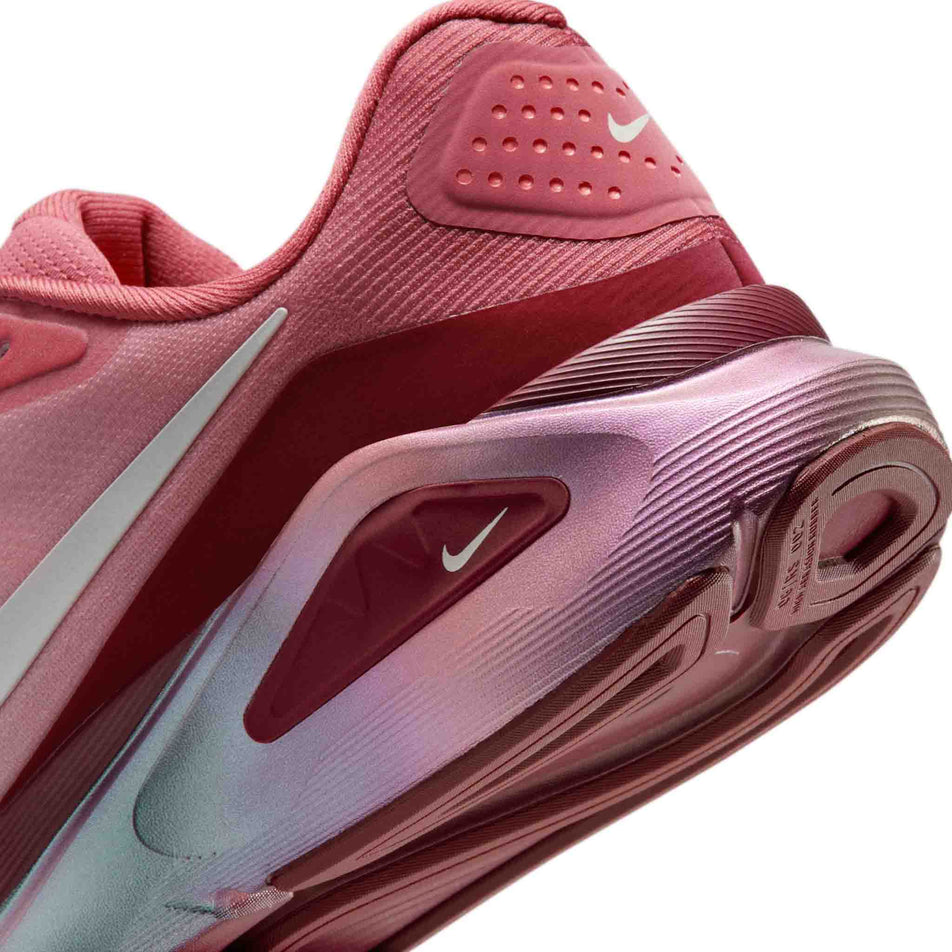 Close-up view of the rearfoot section of the left shoe from a pair of Nike Women's Structure 26 Road Running Shoes in the Light Redwood/Barely Green-Team Red colourway.