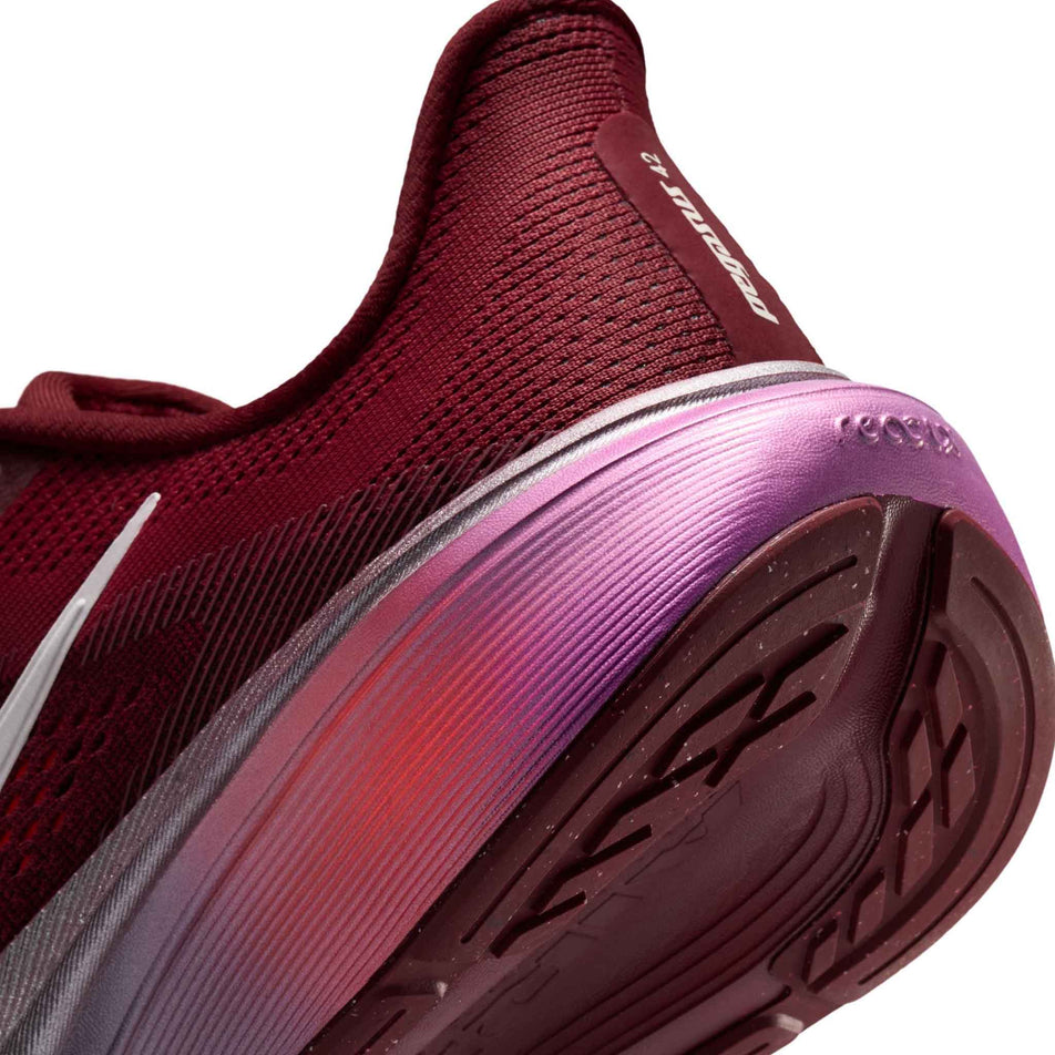 Close-up view of the rearfoot section of the left shoe from a pair of Nike Women's Pegasus 42 SE Road Running Shoes in the Team Red/Barely Green-Atomic Pink colourway.