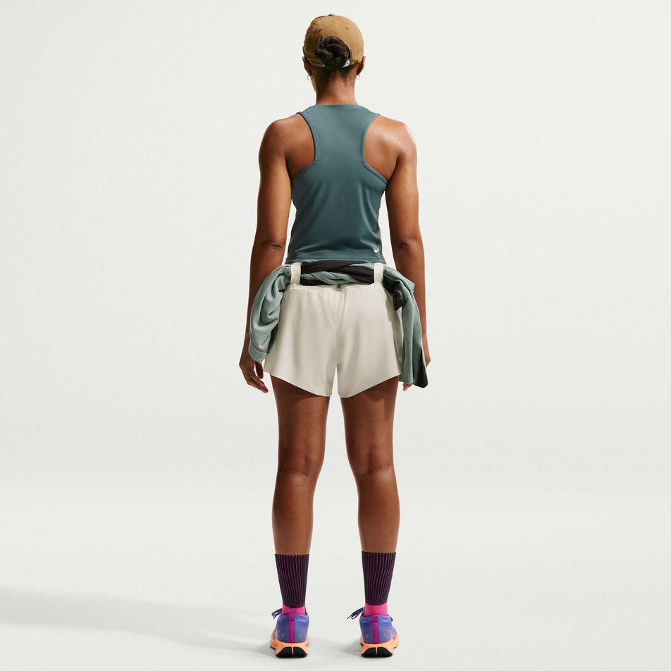Back view of a model wearing the Nike Women's ACG Dri-FIT Mid-Rise Brief-Lined Trail Running Shorts in the Sea Glass/Sea Glass/Summit White colourway.