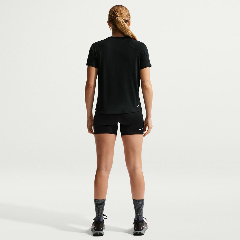 Back view of a model wearing the Nike Women's ACG Dri-FIT Short-Sleeve Trail Running Top in the Black/Summit White colourway.