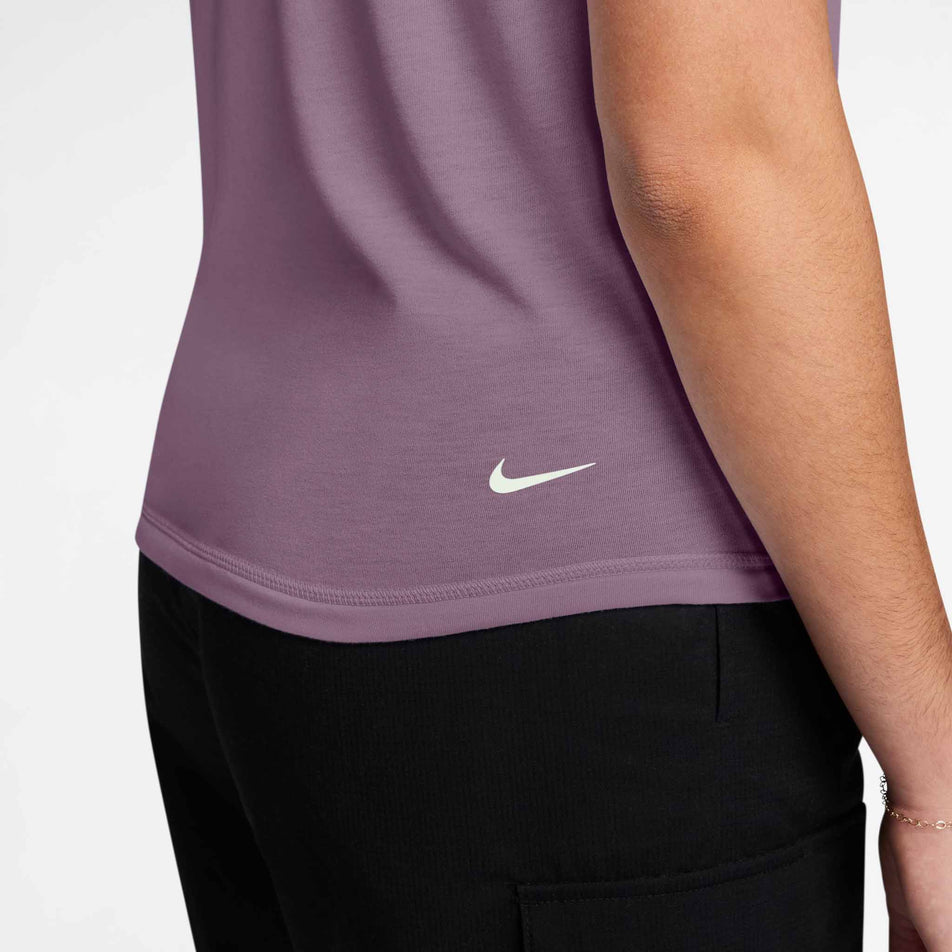 The Swoosh logo on the Nike Women's ACG Dri-FIT Short-Sleeve Trail Running Top in the Violet Dust/Summit White colourway.