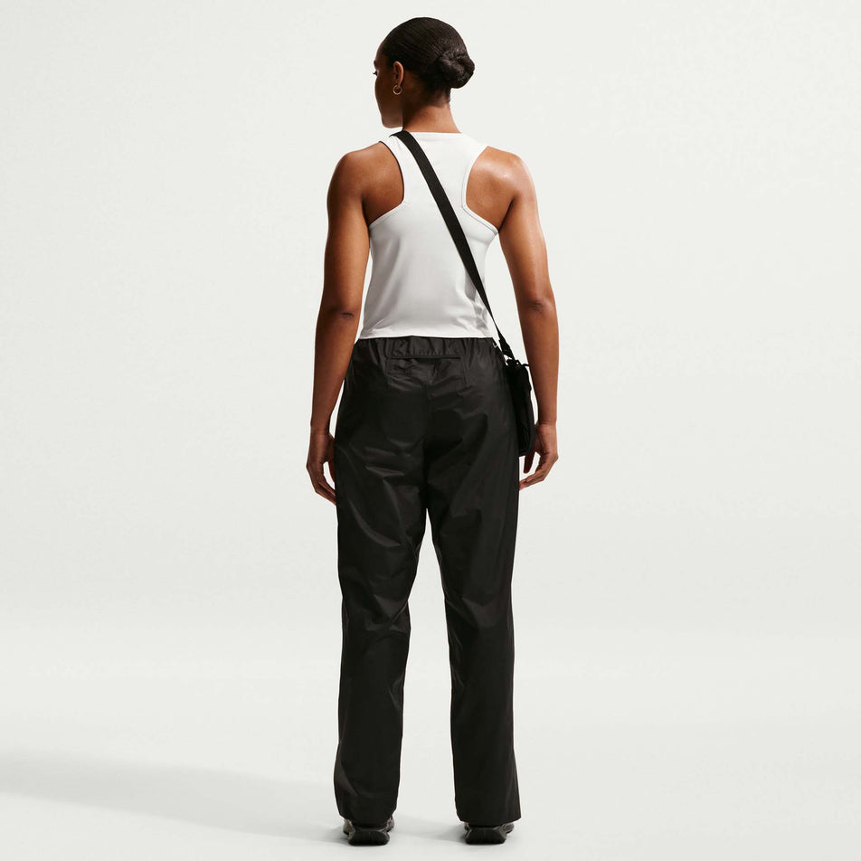 Back view of a model wearing the Nike Women's ACG Dri-FIT Trail Running Tank Top in the Phantom/Photon Dust/Summit White colourway.