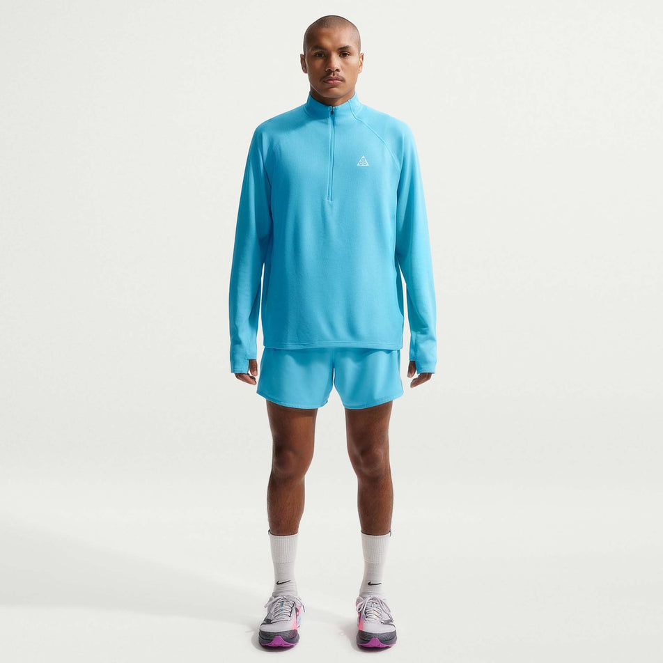 Front view of a model wearing the Nike Men's ACG Dri-FIT Mid-Layer 1/4-Zip Trail Running Top in the Baltic Blue/Baltic Blue/Summit White colourway.