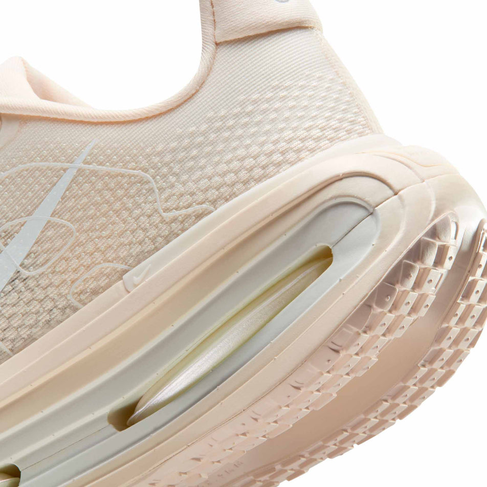 Close-up view of the rearfoot section of the left shoe from a pair of Nike Women's Vomero Premium Road Running Shoes in the  Chalk/White-Pale Ivory-Summit White colourway.
