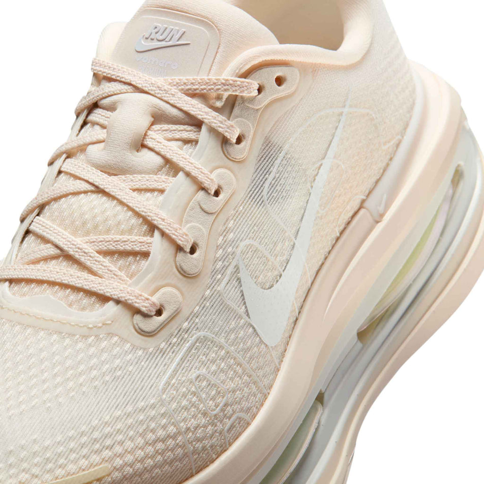 Close-up view of the upper of the left shoe from a pair of Nike Women's Vomero Premium Road Running Shoes in the  Chalk/White-Pale Ivory-Summit White colourway.
