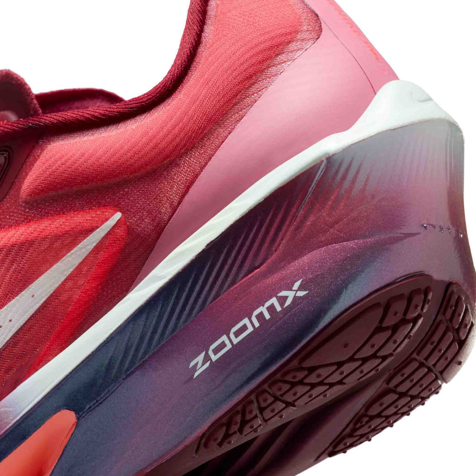 Close-up view of the rearfoot section of the left shoe from a pair of Nike Women's Zoom Fly 6 SE Road Running Shoes in the Team Red/Barely Green-Bright Crimson colourway.