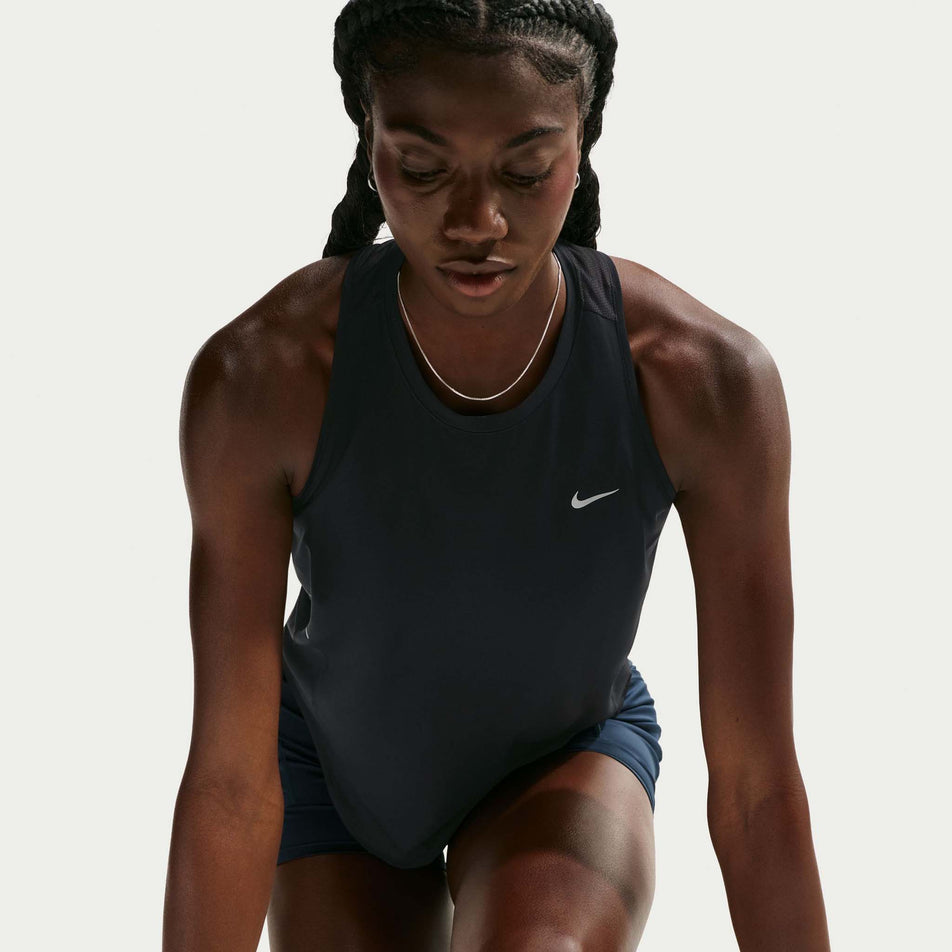 Front view of a model wearing the Nike Women's Swift Dri-FIT Running Tank Top in the Black/Reflective Silver colourway.