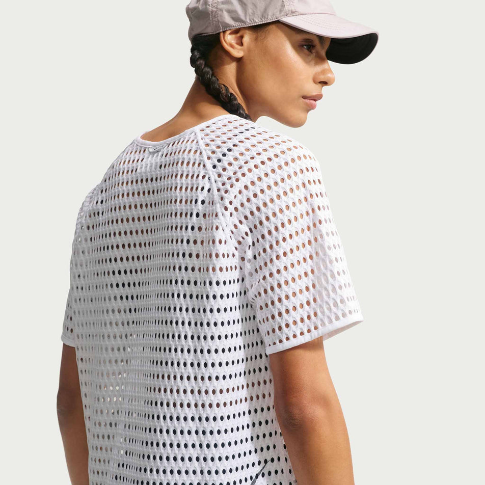 Back view of a model wearing the Nike Women's ACG Radical AirFlow Dri-FIT Short-Sleeve Trail Running Top in the White/Anthracite colourway.
