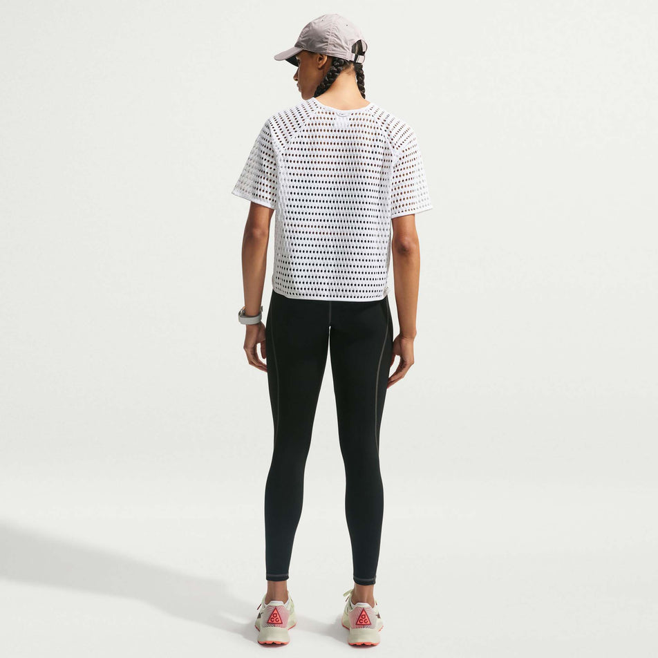 Back view of a model wearing the Nike Women's ACG Radical AirFlow Dri-FIT Short-Sleeve Trail Running Top in the White/Anthracite colourway.