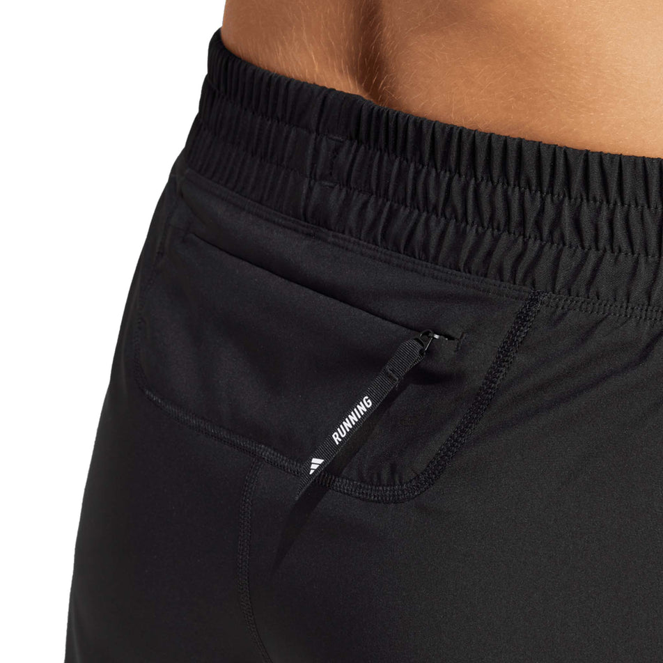 Close up of zip pocket on the adidas Women's Own The Run Base 2in1 Short in the Black colourway. (8665239847074)