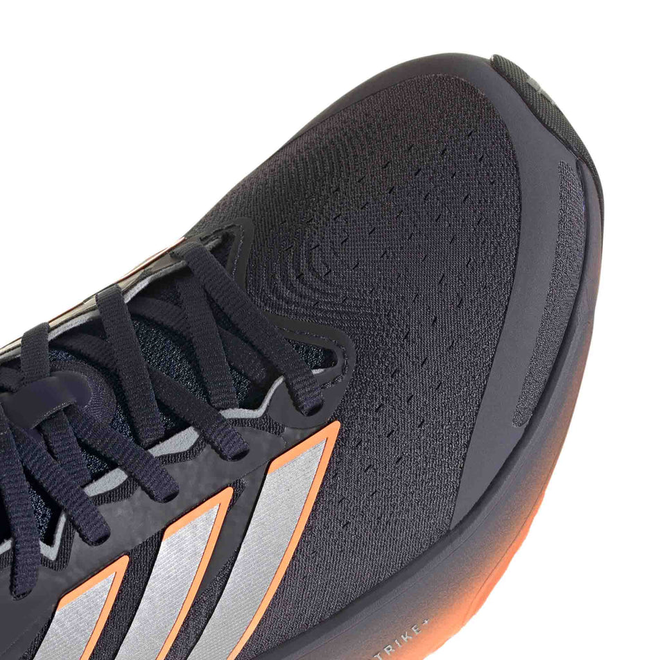 Close-up view of the toebox of the right shoe from a pair of adidas Men's Supernova Solution 3 Running Shoes in the Aurora Onix/Silver met./Lucid Orange colourway.